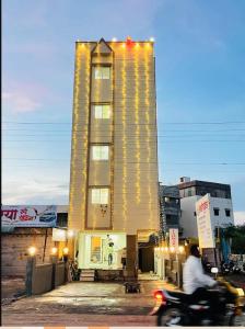 a person riding a motorcycle in front of a building at ishwari heights lodging in Pandharpur