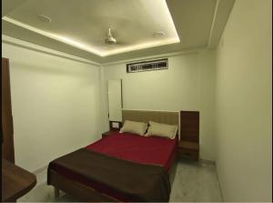 a bedroom with a bed with a red blanket at ishwari heights lodging in Pandharpur