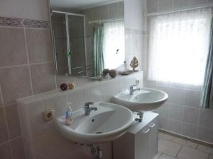 a bathroom with two sinks and a mirror and a window at Ferienhof Saalendorf in Großschönau +25 photos