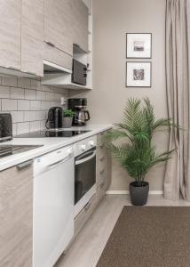 a kitchen with white cabinets and a potted plant at Calm Design Studio with Balcony & Parking in Pori