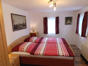 a bedroom with a bed with a red and white comforter at Ferienhof Saalendorf in Großschönau