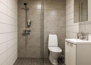 a bathroom with a shower with a toilet and a sink at Calm Design Studio with Balcony & Parking in Pori