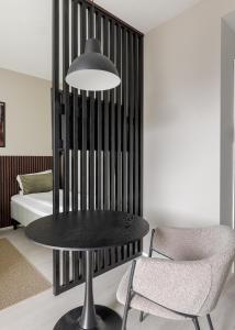 a table and chairs in a room with a bed at Calm Design Studio with Balcony & Parking in Pori +9 photos