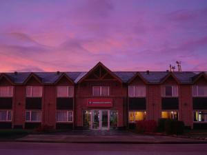 a large red brick building with a purple sky at Marcopolo Suites Calafate in El Calafate