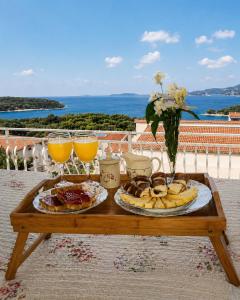a table with two plates of food and glasses of orange juice at Apartments Tonći and Iris in Primošten
