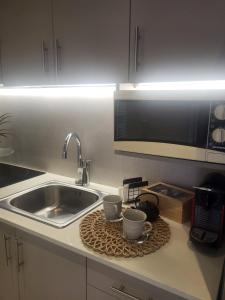 eine Küchentheke mit zwei Tassen und einem Spülbecken in der Unterkunft Centro casa in Arta