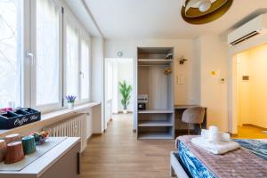 a room with a bed and a desk and windows at Madame Bologna in Bologna