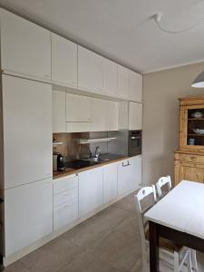 a kitchen with white cabinets and a table at La Casina di Titty in Stia