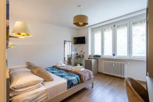 a bedroom with a bed and a large window at Madame Bologna in Bologna