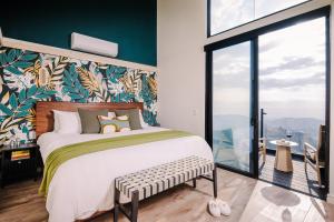 a bedroom with a large bed with a green and white wall at Lakay Monteverde with Heated Pool, Golf Cart and Breakfast in Monteverde Costa Rica