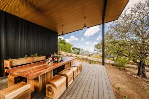 an outdoor patio with a wooden table and benches at Lakay Monteverde with Heated Pool, Golf Cart and Breakfast in Monteverde Costa Rica