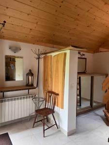 a chair in a room with a wooden ceiling at Przy ścieżce in Węgierska Górka