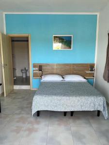 a bedroom with a bed and a blue wall at B&B Torre del lago 2 in Foce Varano