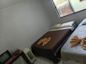 two beds in a room with bows on them at Hotel X in Valparaíso de Goiás