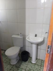 a bathroom with a toilet and a sink at Hotel X in Valparaíso de Goiás