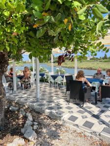 a group of people sitting at tables under a tree at B&B Torre del lago 2 in Foce Varano