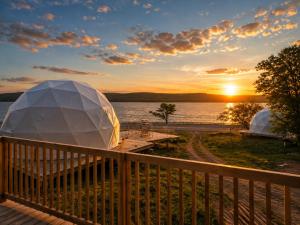 an igloo on the deck of a house with the sunset at Baddeck Domes in Baddeck