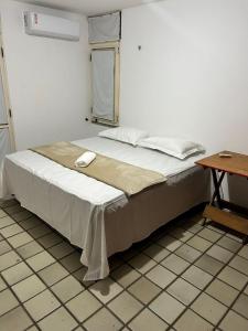 a large bed in a room with a table at Pousada Cajueiro Beach House in Parnaíba