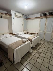 a hospital room with two beds and a window at Pousada Cajueiro Beach House in Parnaíba +5 photos