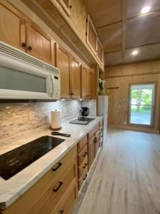 a kitchen with wooden cabinets and a sink and a microwave at Tiny Home in Lawrenceville in Lawrenceville