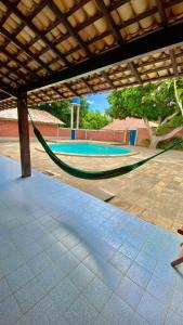 a hammock in front of a swimming pool at Pousada Cajueiro Beach House in Parnaíba