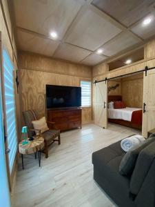 a living room with a couch and a bed and a television at Tiny Home in Lawrenceville in Lawrenceville