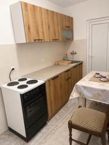 a kitchen with a black and white stove and a table at Apartman Suzana in Šušanj