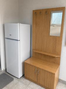 a kitchen with a white refrigerator and a wooden cabinet at Apartman Suzana in Šušanj