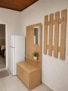 a kitchen with a refrigerator and a shelf with a plant at Apartman Suzana in Šušanj