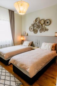 a bedroom with two beds and a chandelier at Oakville House - Kosmaj - Avala in Mala Ivanča +18 photos