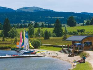 un grupo de barcos en un río con playa en Appartement Col de la Faucille, en Mijoux