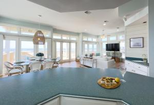 a kitchen and living room with a bowl of fruit on a counter at Oceanfront/Zero Steps to Beach/Views/4BR in Gulf Shores +40 photos