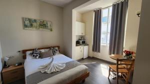 a bedroom with a bed and a table and a window at David Hameleh House in Netanya