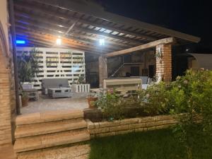 a patio at night with a table and a grill at Il Casale in Soiano del Lago