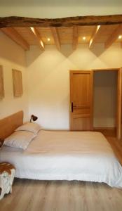 a bedroom with a white bed with a wooden ceiling at Chambres d'hôtes St Jacques Adults only in Saint-Lizier