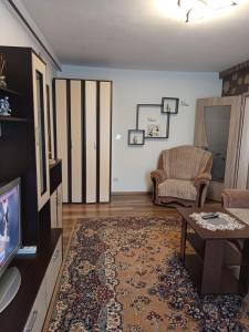 a living room with a tv and a couch and a table at Modern Beach Apartment in Constanţa
