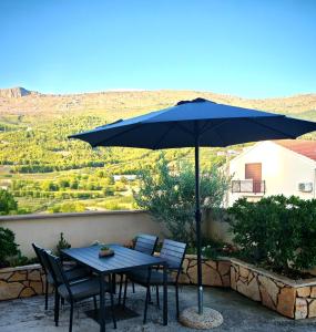 a table and chairs under an umbrella on a patio at Lifestyle apartment Podstrana in Podstrana