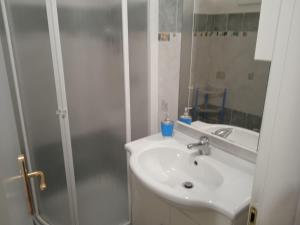 a white bathroom with a sink and a shower at Casa Vacanza da Luigi in Opi