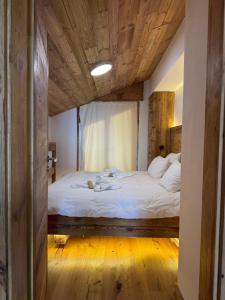 a bedroom with a large bed with a wooden ceiling at Attique de la Moubra 4 in Crans-Montana