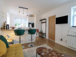 a living room with a couch and a kitchen at Oakwood Annexe in Colchester