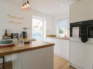 a kitchen with white cabinets and a wooden counter top at Oakwood Annexe in Colchester