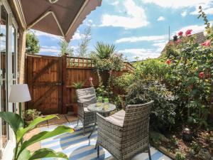 a patio with a table and chairs and a fence at Oakwood Annexe in Colchester