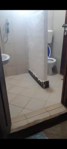 a bathroom with a shower and a toilet in it at Mango Lodge MSAMBWENI in Kisimachande +80 photos