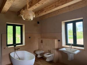 a bathroom with two sinks and a tub and two toilets at Zawiszyn 12 in Dubeninki +10 photos