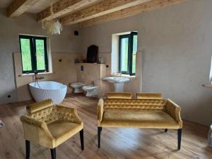 a bathroom with a couch and a tub and a sink at Zawiszyn 12 in Dubeninki