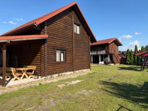 a log cabin with a picnic table in front of it at Релакс in Svityazʼ