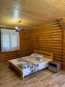a bedroom with a bed in a wooden room at Релакс in Svityazʼ