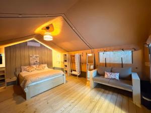 ein Schlafzimmer mit einem Bett und einer Couch in einem Zimmer in der Unterkunft Anna Glamping in Fuen Negra