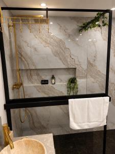 a bathroom with a marble shower with a sink at Suite avec jacuzzi DOLCE NOTTE in Rochegude