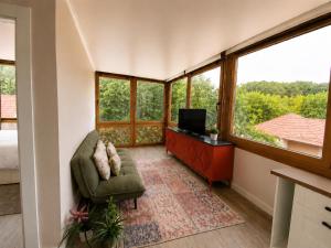 a room with a couch and a tv and windows at Storytellers Boutique Villas in Sintra